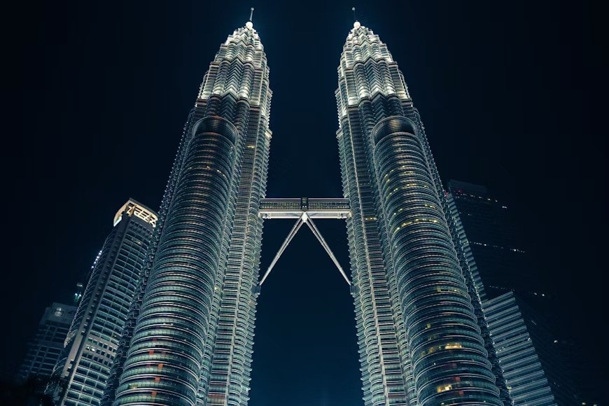 Petronas Twin Towers illuminated at night against dark sky in Kuala Lumpur